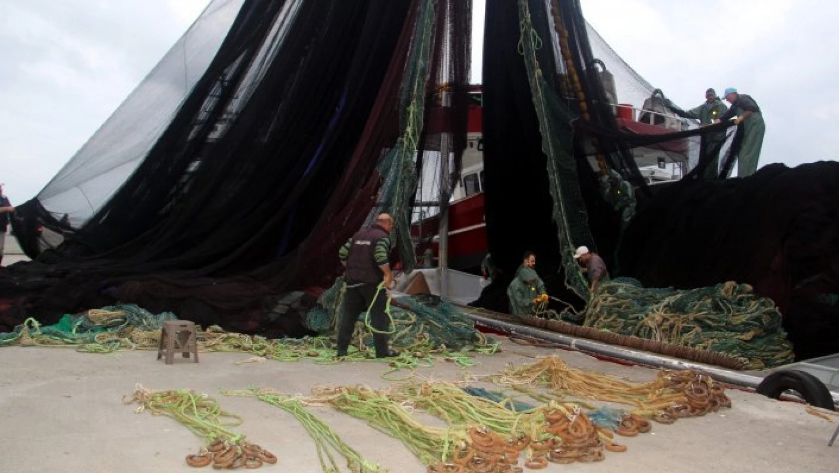 Karadenizli balıkçılar ağlarını hamsi avı için onarıyor